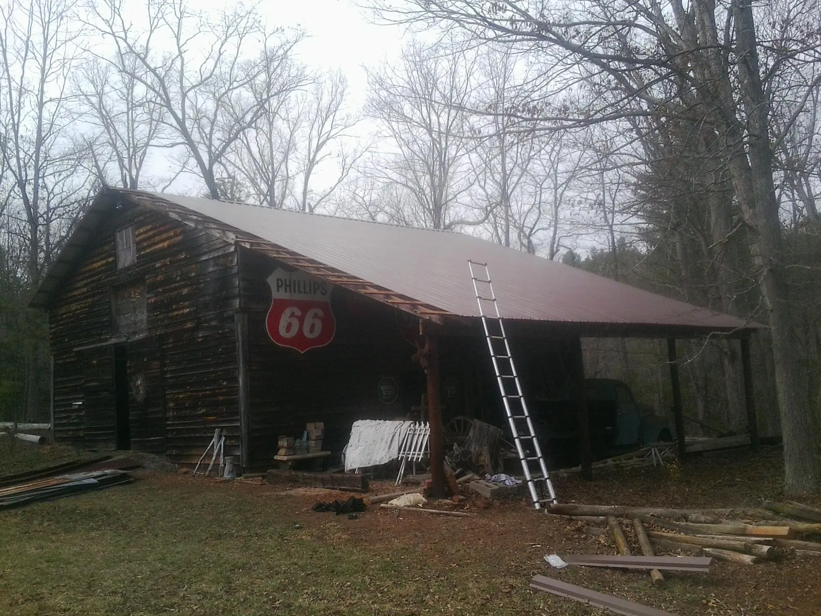 New metal roof on an open sided timber barn with a vintage sign in Onaga