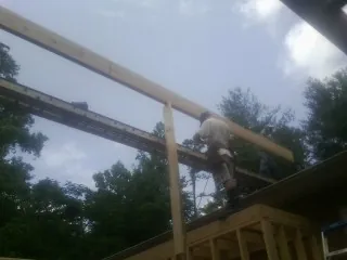 Carpenter setting a ridge beam over a new addition frame — Ice Dam Removal by Roofing Brothers in Onaga