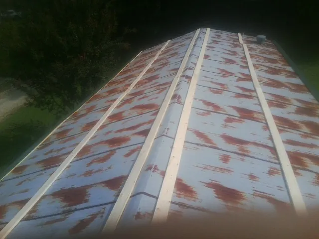 Rusted metal roof panels with new wood purlins before replacement — Storm Damage Roof Repair in Onaga by Roofing Brothers
