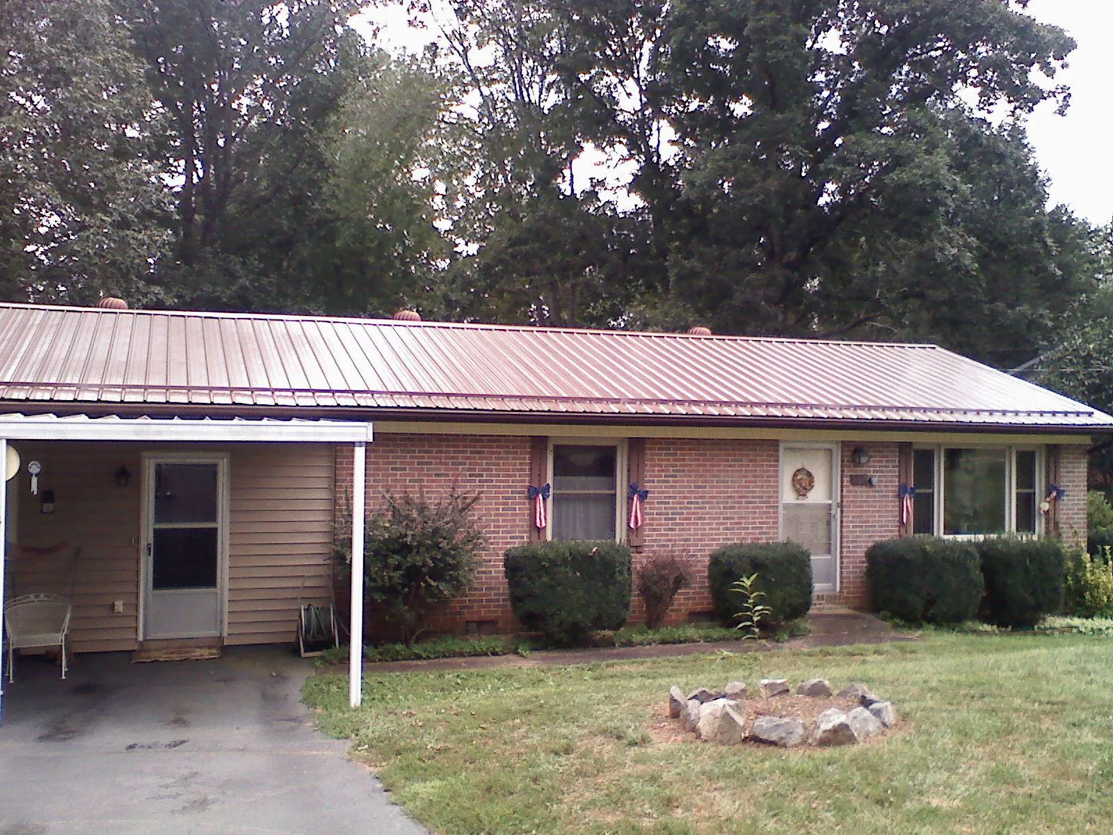 Bronze metal roof and carport on a brick ranch home — Roof Repair work by our crew in Onaga